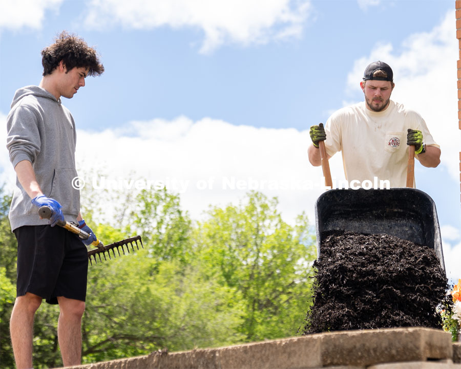 Pi Kappa Alpha’s Grant Breidenbach waits for Ethan Heinemann to supply more mulch for him to spread out at the Van Dorn Villa Retirement Living complex during the Big Event. May 4, 2024. Photo by Kirk Rangel for University Communication.